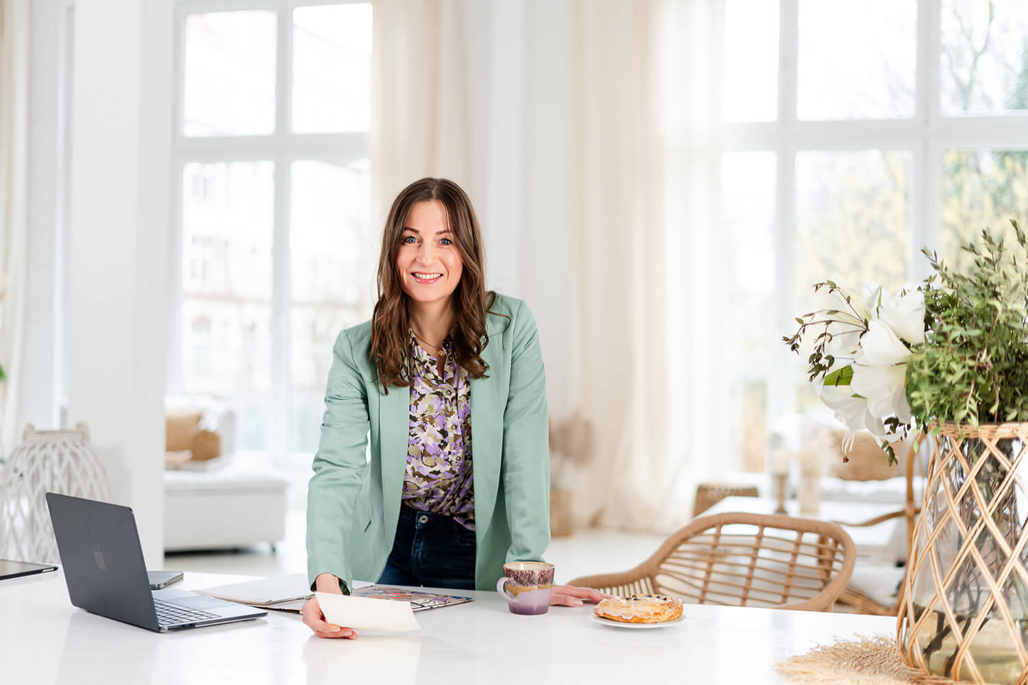 Frau in einem hellen Zimmer mit Laptop.